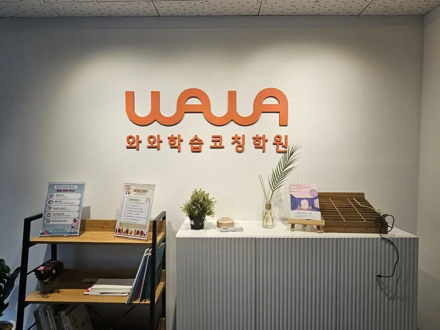 주황색 WAWA 로고 아래 화분과 안내 거치대가 놓인 다산도농점 입구 로비