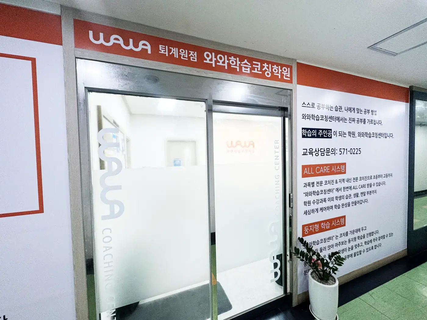 주황색 와와 간판과 반투명 유리문이 있는 퇴계원점 출입구