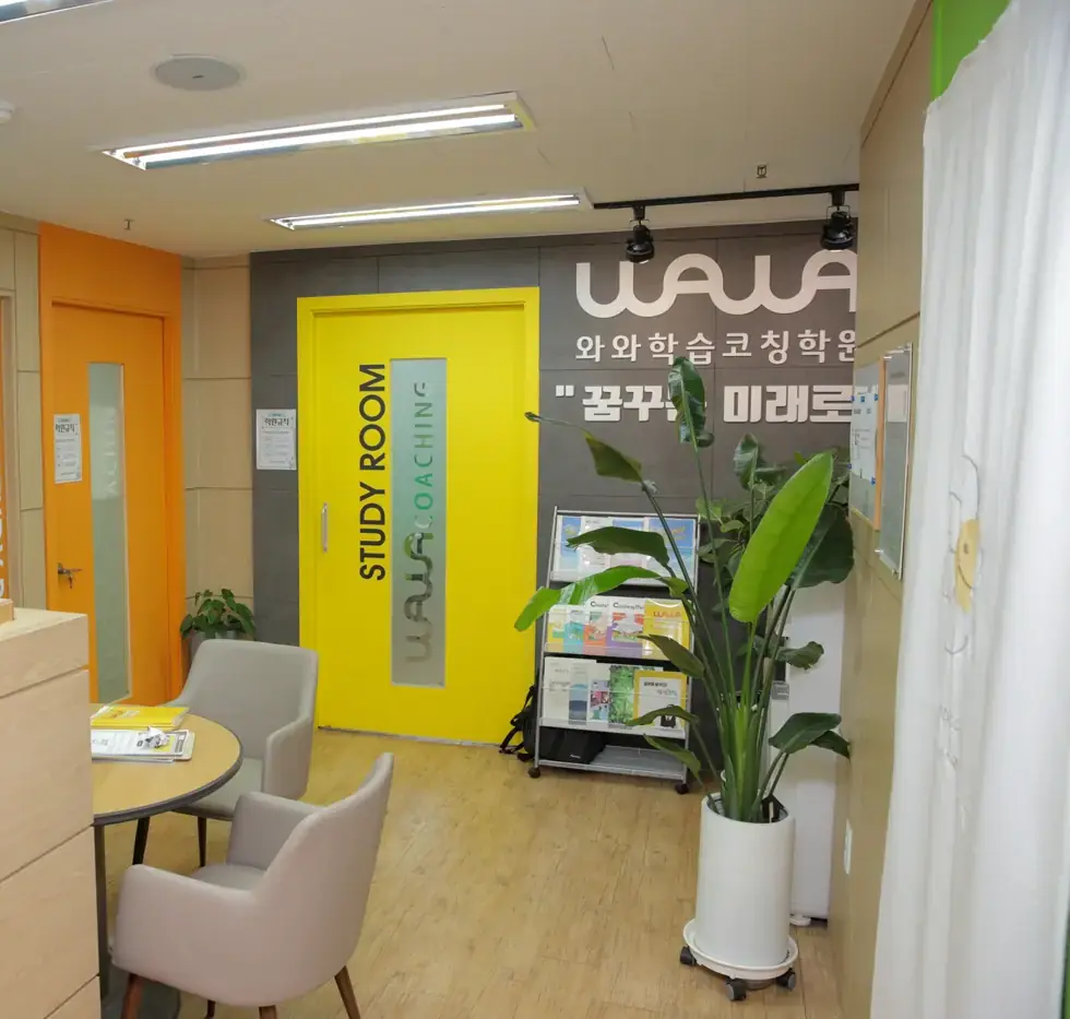 노란 STUDY ROOM 문과 회색 벽 WAWA 간판, 원형 테이블이 있는 돈암점 로비