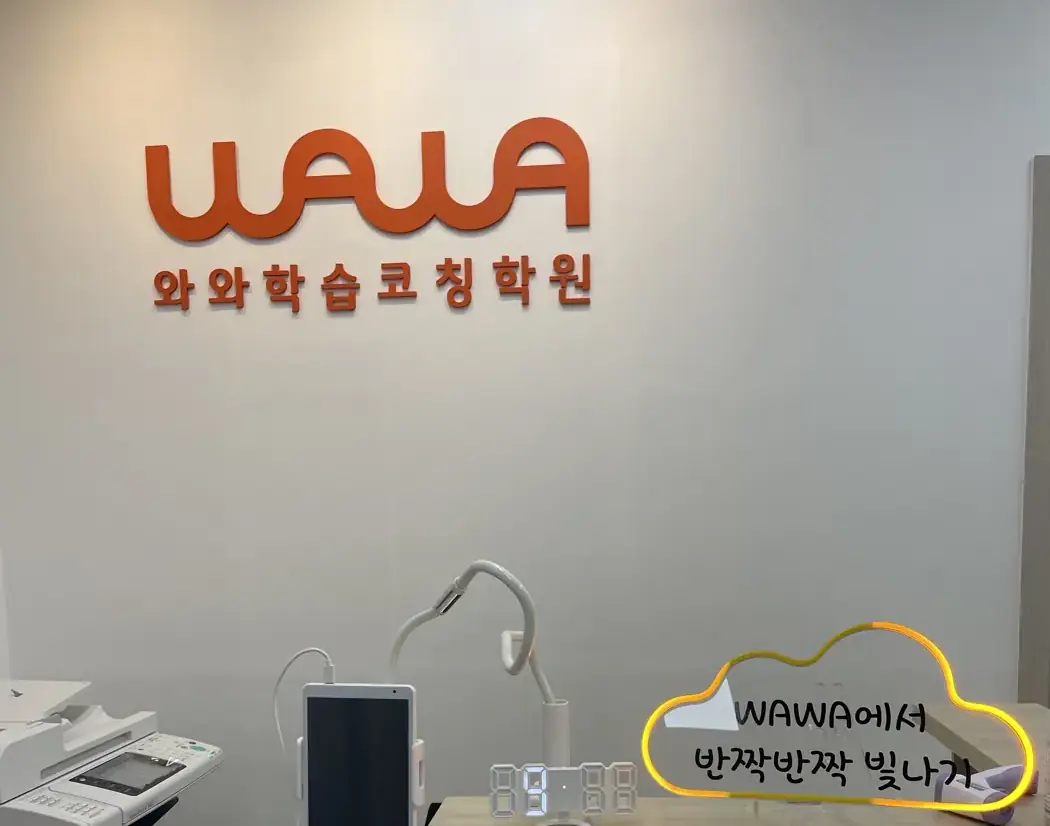 주황색 WAWA 로고 아래 구름 모양 조명과 태블릿이 놓인 남외점 안내 데스크